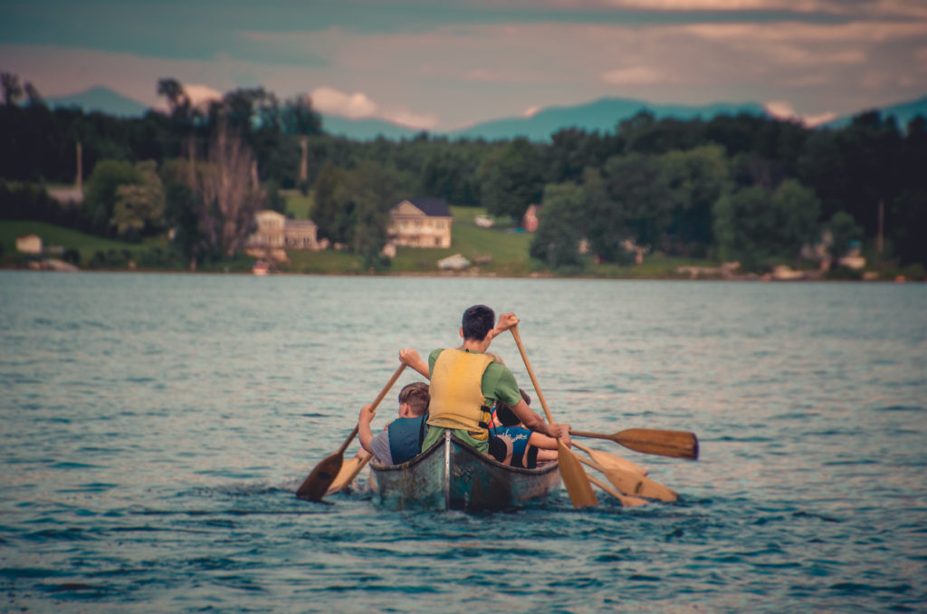 Campers and their counselor rowing in a canoe 