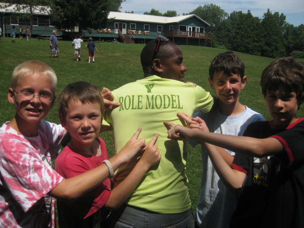 Campers pointing to the text Role Model on their counselor's shirt