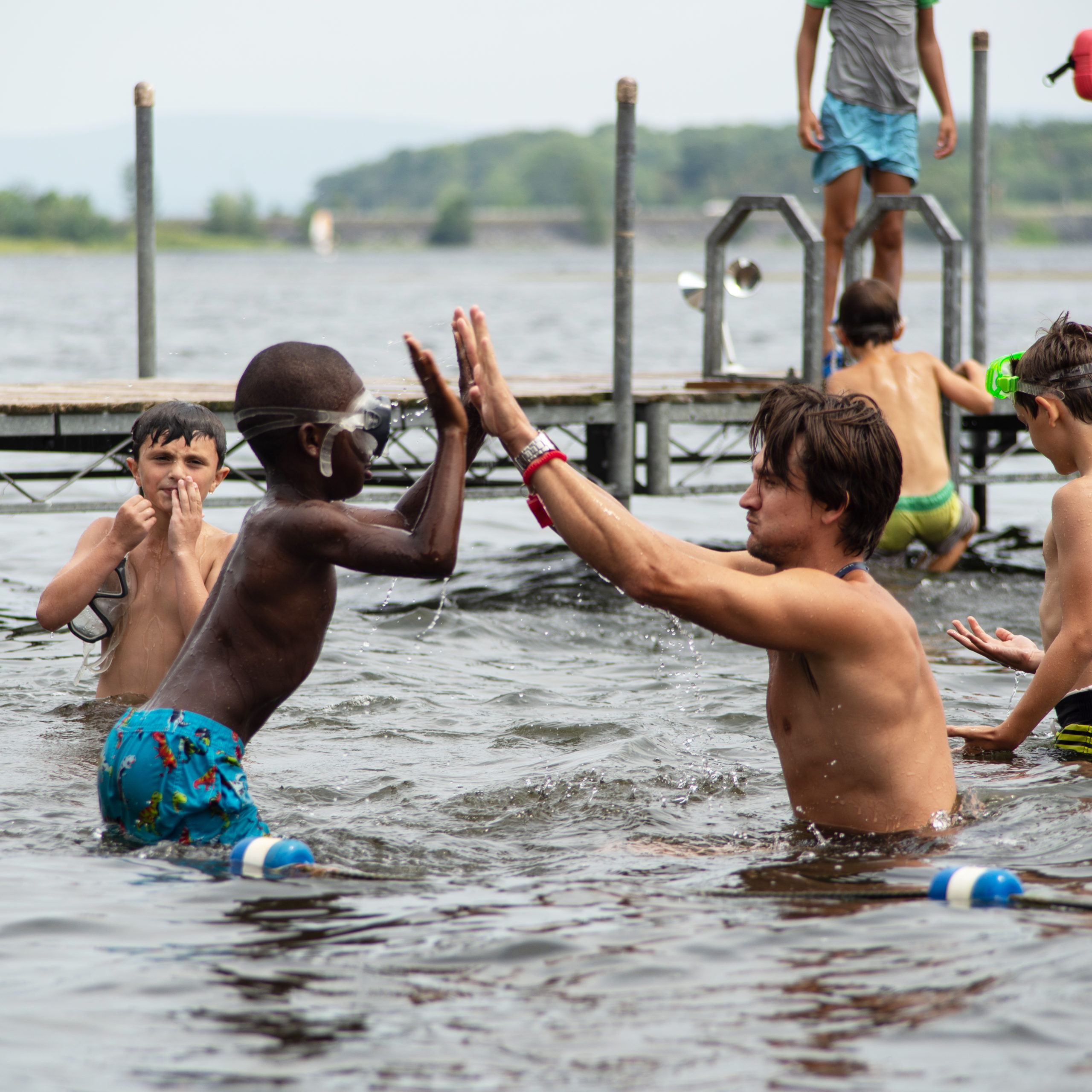 Counselor and campers playing in the lake